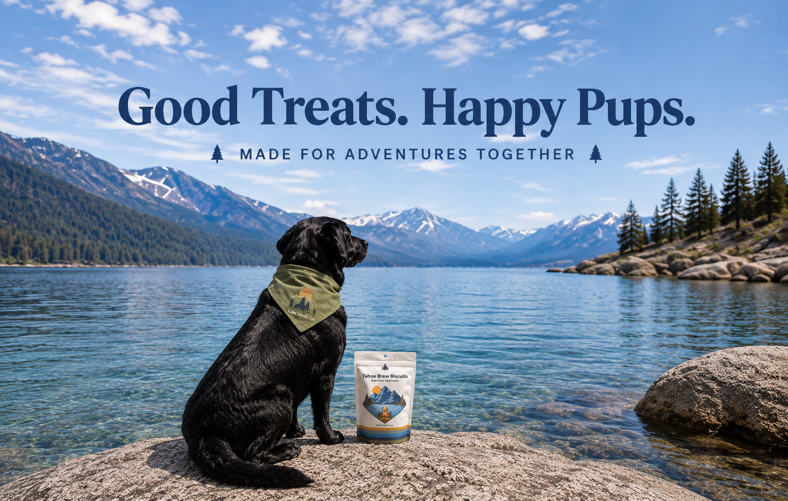 Image of a mountain lake scene. There are mountains, trees, a clear lake and a dog sitting on a rock wearing a Lake Tahoe Bandana. There is a bag of Tahoe Brew Biscuits next to the dog.